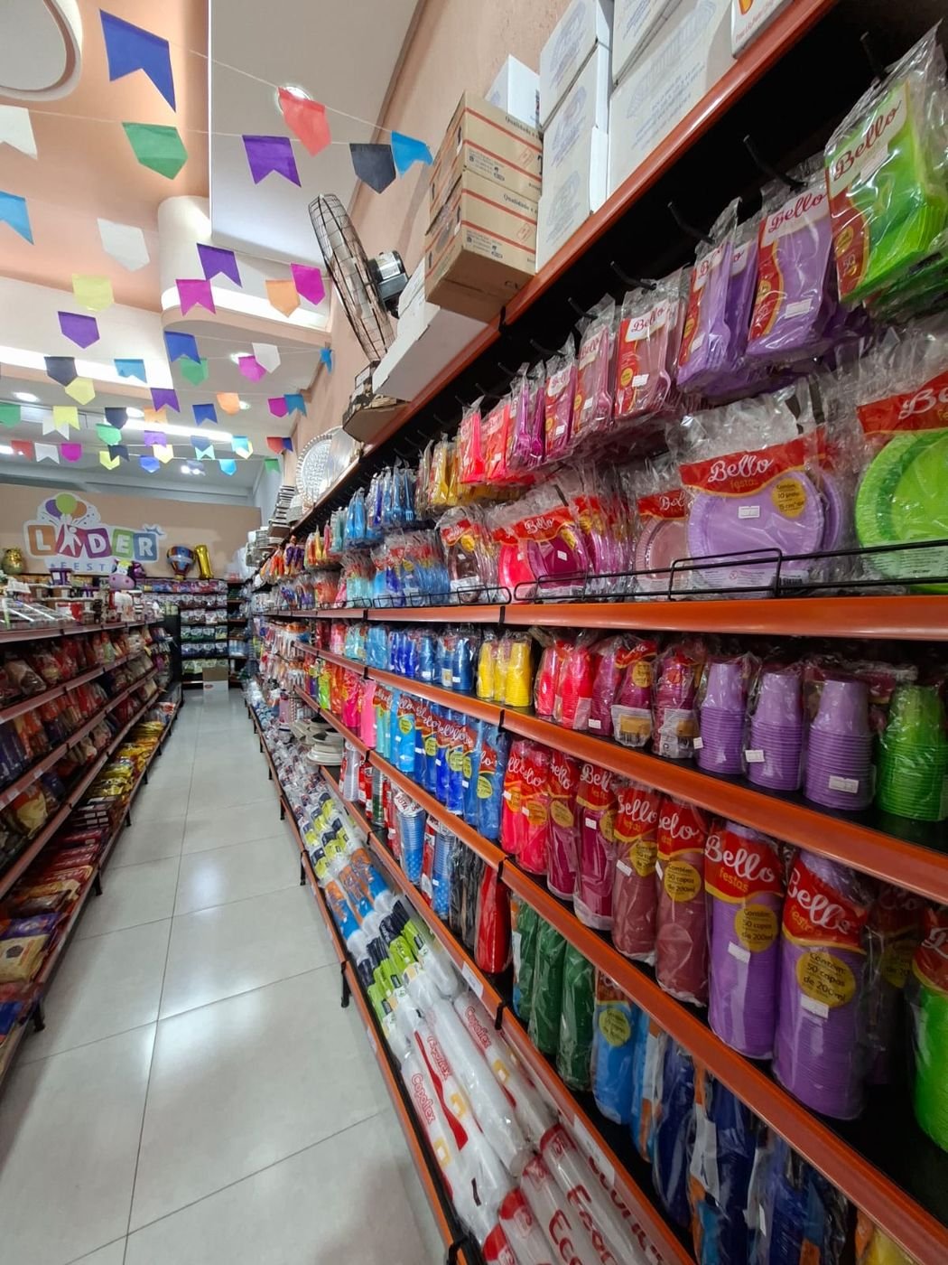Copos e pratos descartáveis coloridos Bello Festas expostos na loja